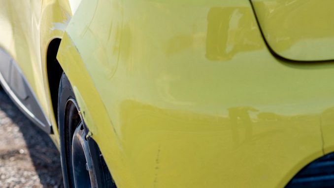 scratched car with damaged paint in crash accident or parking lot
